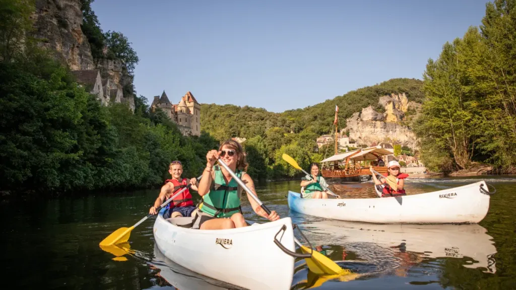 Deux canoës d’amis glissant sur la Dordogne au pied des falaises, à dix minutes de Sarlat